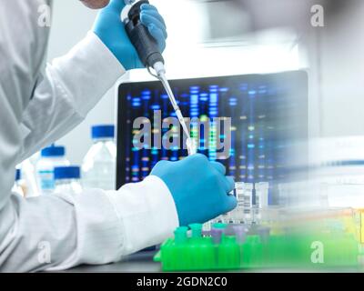Pipettaggio del campione da parte dello scienziato in una fiala per l'analisi del DNA Foto Stock