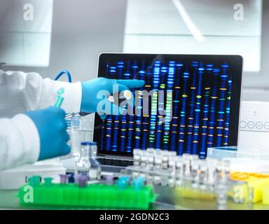Scienziato che osserva i risultati del DNA dai campioni nel laboratorio. Foto Stock