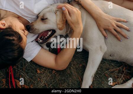 Donna che abbraccia il suo Labrador all'aperto. Stili di vita e concetto di cura degli animali domestici. Foto Stock