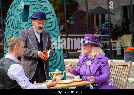 Stroud, Glos, Regno Unito. 14 agosto 2021. Tutte le cose Steampunk sono celebrate oggi a Stratford Park e il Museo nel Parco di Stroud. Steampunk è un genere fantascientifico con le sue radici in H G Wells e Jules Verne, caratterizzato dalla moda vittoriana e il desiderio di fuggire in un passato che non è ancora successo. Nella foto è raffigurato un duello di tè, che si dunking con la minaccia. Credit: JMF News/Alamy Live News Foto Stock