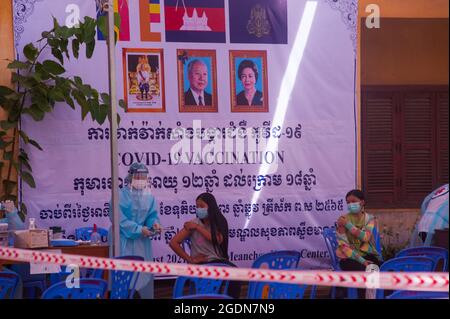 Phnom Penh, Cambogia. 14 agosto 2021. Da oltre 5 mesi Phnom Penh sta combattendo contro un aumento di COVID - 19. Il governo cambogiano rimane sulla rotta con il suo programma di vaccinazione per i bambini da 12 a 17 anni in un sito di vaccinazione di massa. EMT / farmaci in pieno PPE somministrare i vaccini agli adolescenti. Credit: Kraig Lieb / Alamy Live News Foto Stock