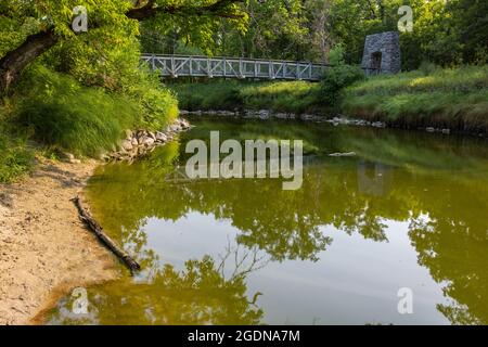 Ponte pedonale Swing sul fiume nel bosco Foto Stock