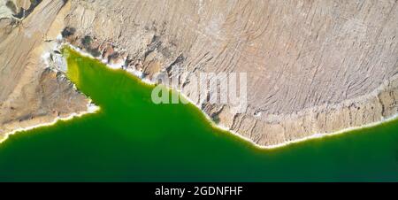 Riva di lago verde tossico nella miniera di rame a cielo aperto abbandonata, il suo colore deriva da alti livelli di metalli acidi e pesanti. Panorama aereo da directl Foto Stock