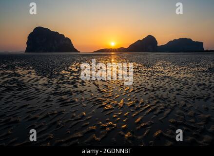 Sabbia onde texture con riflesso del tramonto sulla spiaggia di Pak Meng, Trang, Thailandia Foto Stock