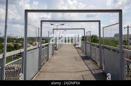Ponte ferroviario con scalini, con scalini impressionanti in prospettiva. Attraversamento pedonale in alto. Ponte scale che collegano una piattaforma a un'altra presso Foto Stock