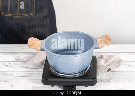 Preparare il composto misto di frutti di bosco surgelati in una pentola da cucina antiaderente. Foto Stock