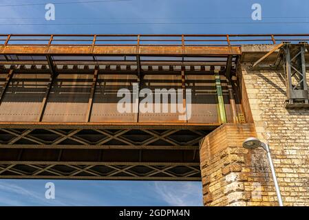 La struttura reticolare in acciaio del ponte ferroviario vista dal basso contro il cielo blu. Foto Stock