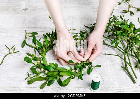 Fiorista al lavoro: Come fare mistletoe porta corona, passo dopo passo, tutorial. Foto Stock