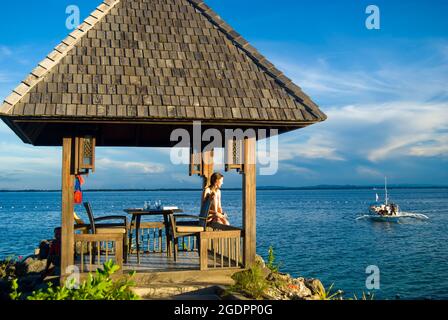 Bordo d'acqua rifugio al tramonto, Shangri-La Island Resort & Spa, Mactan Island, Cebu, Visayas, Filippine Foto Stock