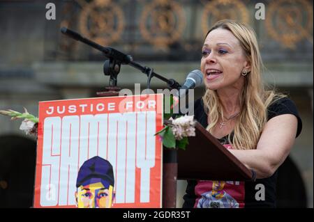 La madre della vittima, Justine Seewald, dà un discorso emotivo, condannando l'azione della polizia per l'uccisione di suo figlio.la manifestazione di questa sera ha attratto un numero equo di sostenitori e l'oratore principale per la serata è stata la madre della vittima Justine Seewald. Un giovane muscoloso è stato visto in video facendo una registrazione sul suo telefono, vestito in pantaloncini, i suoi occhiali da sole sulla testa e premendo un coltello alla propria gola. Fu visto in un cortile, dove diversi poliziotti lo chiedevano di fermarsi. Mentre camminava verso di loro, un gestore di cane della polizia ha rilasciato il suo cane dietro di lui, ma, l'animale d Foto Stock