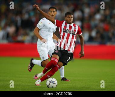 Swansea, Galles, 14 agosto 2021. Rhian Brewster di Sheffield Utd si dirige nello spazio passando accanto al ben Canango di Swansea City durante la partita del campionato Sky Bet allo stadio Swansea.com di Swansea. L'immagine di credito dovrebbe essere: Simon Bellis / Sportimage Foto Stock