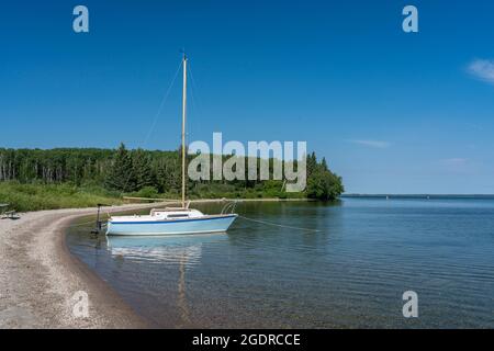 Una barca a vela sulla riva del lago Clear, Riding Mountain National Park, Manitoba, Canada. Foto Stock