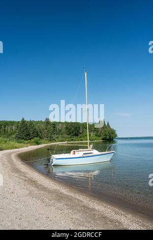 Una barca a vela sulla riva del lago Clear, Riding Mountain National Park, Manitoba, Canada. Foto Stock