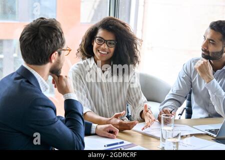 Il team aziendale internazionale discute di un progetto aziendale nella sala riunioni. Foto Stock