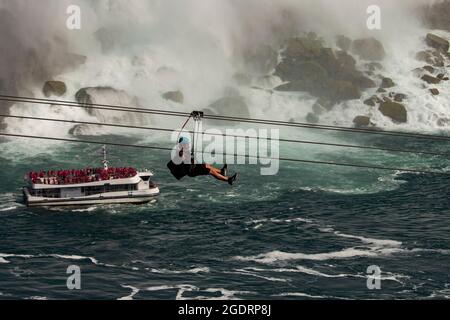 CASCATE DEL NIAGARA, ONTARIO, CANADA - AGOSTO 9/2021 - turisti che si godono un'avventura in zipline alle Cascate del Niagara. Foto Stock