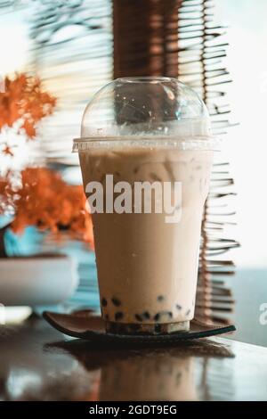 Tè al latte ghiacciato con albero di bonsai artificiale in un caffè in stile giapponese Foto Stock