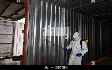 Haikou, provincia cinese di Hainan. 15 agosto 2021. Un membro del personale disinfetta un camion di consegna in un centro di trasporto di consegna a Haikou, nella provincia di Hainan della Cina meridionale, 15 agosto 2021. Credit: Yang Guanyu/Xinhua/Alamy Live News Foto Stock