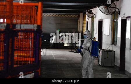 Haikou, provincia cinese di Hainan. 15 agosto 2021. Un membro dello staff disinfetta un deposito presso un centro di trasporto di consegna a Haikou, nella provincia di Hainan, nella Cina meridionale, 15 agosto 2021. Credit: Yang Guanyu/Xinhua/Alamy Live News Foto Stock