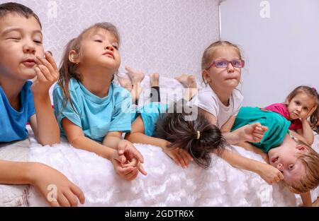 i bambini si stendono sul divano, i bambini si divertono insieme Foto Stock