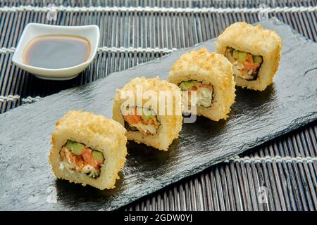 panini caldi deliziosi con salmone, formaggio spalmabile, cetriolo, caviale, masago, pangrattato e salsa piccante. Foto Stock