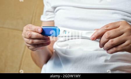 La donna irriconoscibile trasforma il test di gravidanza positivo in telecamera Foto Stock