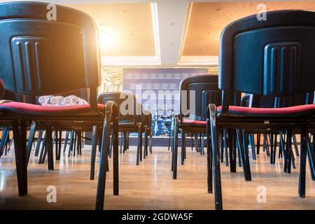 Una fila di sedie da ufficio allestite per una conferenza stampa Foto Stock