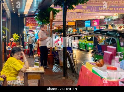 Venditori di strada che vendono frutta e bevande mentre il traffico è pesante di notte, Yaowarat Rd, Chinatown, Bangkok, Thailandia Foto Stock