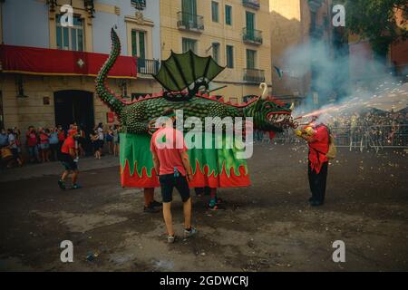 Barcellona, Spagna. 15 agosto 2021. 'Drac' la bestia del fuoco stabilisce le sue scintille volanti inaugurando la 'Festa Major de Gracia'. Questa cavalcata non annunciata attraverso il quartiere Gracia di Barcellona è stato l'inizio di una versione ridotta e limitata di questo famoso festival a causa della crisi COVI19 in corso. Credit: Matthias Oesterle/Alamy Live News Foto Stock