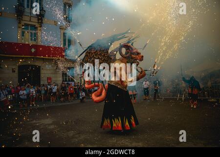 Barcellona, Spagna. 15 agosto 2021. 'Atzeries' la bestia del fuoco delle sue scintille volanti inaugurando la 'Festa Major de Gracia'. Questa cavalcata non annunciata attraverso il quartiere Gracia di Barcellona è stato l'inizio di una versione ridotta e limitata di questo famoso festival a causa della crisi COVI19 in corso. Credit: Matthias Oesterle/Alamy Live News Foto Stock