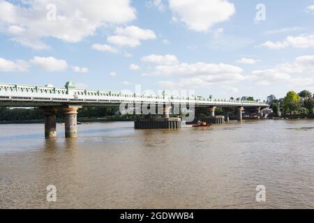 Una scialuppa gonfiabile RNLI passa sotto il Fulham Railway Bridge, Fulham, Londra, Inghilterra, Regno Unito Foto Stock