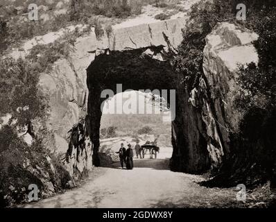 Una vista del tardo 19 ° secolo dei turisti che arrivano in pony e trappola al tunnel sul Kenmnare a Killarney Road nel Killarney National Park nella contea di Kerry, Irlanda Foto Stock