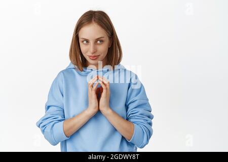 HMM interessante. Giovane donna che schedava smth, guardando da parte con viso sbavato, dita rubate astuzia, ha devioso genio piano male, stare misterioso a. Foto Stock