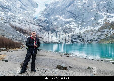 Incredibile ghiacciaio Briksdalsbre Briksdalsbreen in the Winder con un modello turistico o viaggiatore in Stryn Norvegia Foto Stock