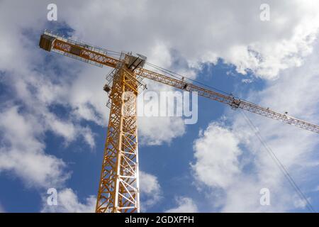 Gru di costruzione contro il cielo blu. Gru beige nel cantiere. Foto Stock