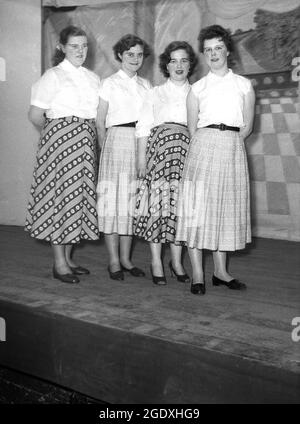 1957, storico, quattro donne esecutori in bluse e lunghe gonne che appaiono nella pantomina Aladdin stand sul palco per la loro foto, Inghilterra, Regno Unito. Foto Stock
