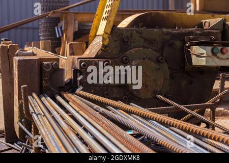 Macchina di taglio per rinforzi. Attrezzature per la lavorazione del metallo in un cantiere. Preparazione di aste di acciaio per la cementazione. Taglio di metallo Foto Stock