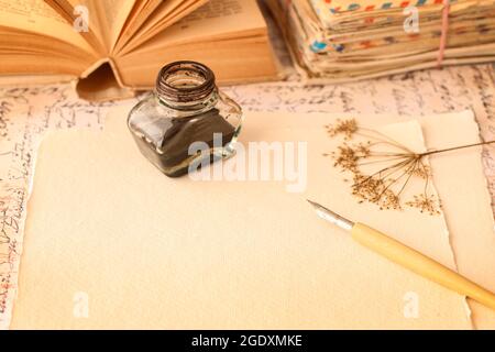 Inkwell, penna e rose secche su sfondo di carta vintage. Idea di lettere d'amore. Saluti di San Valentino. Foto Stock