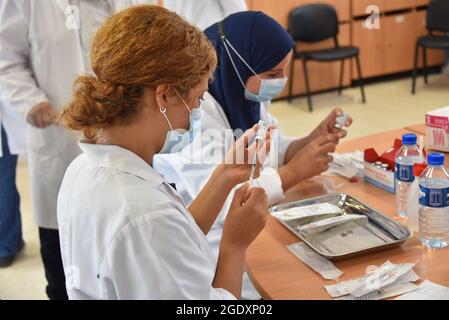 Tunisi, Tunisia. 15 agosto 2021. Gli operatori sanitari si preparano a somministrare dosi di vaccino Moderna COVID-19 a persone in un centro di inoculazione in un edificio delle scuole superiori nella capitale Tunisi. Il direttore generale della sanità tunisina Faycel ben Salah ha detto che circa 1 milione di persone sarà chiamato al 2 ° giorno di vaccinazione intensiva del coronavirus, per i gruppi di 18-39 anni. Credit: SOPA Images Limited/Alamy Live News Foto Stock