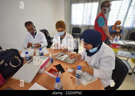 Tunisi, Tunisia. 15 agosto 2021. Gli operatori sanitari si preparano a somministrare dosi di vaccino Moderna COVID-19 a persone in un centro di inoculazione in un edificio delle scuole superiori nella capitale Tunisi. Il direttore generale della sanità tunisina Faycel ben Salah ha detto che circa 1 milione di persone sarà chiamato al 2 ° giorno di vaccinazione intensiva del coronavirus, per i gruppi di 18-39 anni. (Foto di Jdidi Wassim/SOPA Images/Sipa USA) Credit: Sipa USA/Alamy Live News Foto Stock