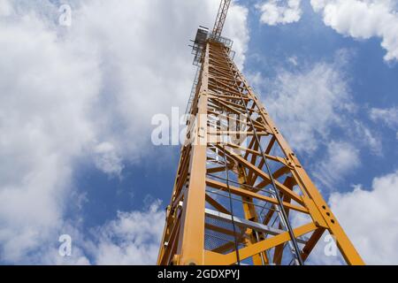 Gru di costruzione contro il cielo blu. Gru beige nel cantiere. Foto Stock