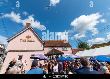 The Bell, Ingatestone, Essex, Regno Unito. 15 Agosto 2021. Una Royal Air Force Battle of Britain Memorial Flight Supermarine Spitfire è stata l'attrazione principale di un pub festival di musica estiva. Il combattente della seconda guerra mondiale, uno Spitfire Mk IIa che combatté nella battaglia della Gran Bretagna, volò dalla sua base a RAF Coningsby nel Lincolnshire per esibire una serie di eventi in tutto il paese. Gli organizzatori sono in grado di richiedere al RAF di essere allestito un espositore se pianificato con largo anticipo, rendendo per occasioni molto speciali per piccoli eventi locali. Persone che puntano verso l'alto in aereo Foto Stock