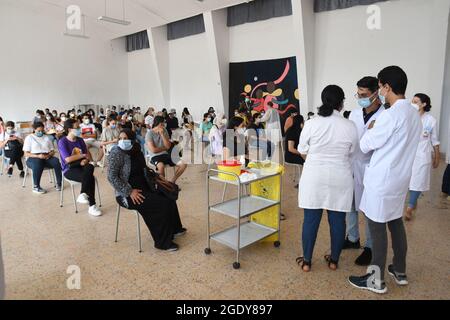 Tunisi, Tunisia. 15 agosto 2021. I tunisini attendono di ricevere il vaccino COVID-19 in un centro di vaccinazione a Tunisi, Tunisia, 15 agosto 2021. La seconda giornata nazionale tunisina aperta per la vaccinazione contro la COVID-19 è iniziata domenica in tutte le 24 province del paese per i cittadini di età compresa tra i 18 e i 39 anni. In tutto 405 centri di vaccinazione, distribuiti in tutto il paese, sono stati allestiti esclusivamente per questa giornata aperta. Credit: Adel Ezzine/Xinhua/Alamy Live News Foto Stock