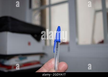 Huelva, Spagna. 4,5.2022. Una mano che regge una penna BIC blu. Foto Stock