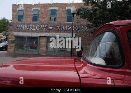 Winslow, Arizona, Stati Uniti. 12 agosto 2021. Standin' on the Corner Park a Winslow, Arizona. Una statua del membro di Eagles Glen Frey commemora la canzone di successo degli anni '60 Take IT Easy con la linea 'bene sono in piedi all'angolo a Winslow, Arizona e una vista così bella da vedere. E' una ragazza, mio Signore, in un letto piatto Ford slowin' down to take a Guardami.'' il parco contiene un murale trompe-l'ceil a due piani di John Hugh e una statua di un uomo che tiene una chitarra dello scultore Ron Adamson. Winslow è una popolare destinazione turistica sulla famosa vecchia Route 66 situata sulla riserva Navajo. (C Foto Stock