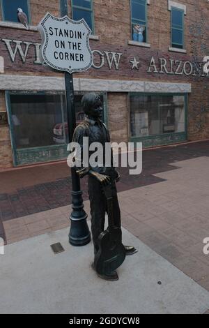 Winslow, Arizona, Stati Uniti. 12 agosto 2021. Standin' on the Corner Park a Winslow, Arizona. Una statua del membro di Eagles Glen Frey commemora la canzone di successo degli anni '60 Take IT Easy con la linea 'bene sono in piedi all'angolo a Winslow, Arizona e una vista così bella da vedere. E' una ragazza, mio Signore, in un letto piatto Ford slowin' down to take a Guardami.'' il parco contiene un murale trompe-l'ceil a due piani di John Hugh e una statua di un uomo che tiene una chitarra dello scultore Ron Adamson. Winslow è una popolare destinazione turistica sulla famosa vecchia Route 66 situata sulla riserva Navajo. (C Foto Stock