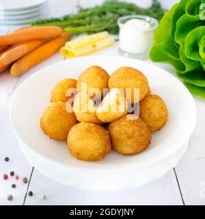 Palle di patate. Cena a base di patate bollite con cipolla e formaggio, fritte nel grasso. Foto Stock