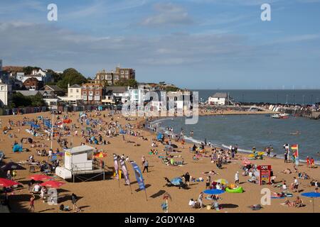 Le persone che godono del sole su una trafficata spiaggia di Broadstairs, Viking Bay Kent UK Foto Stock