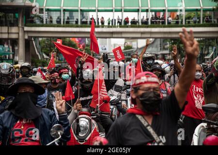 Bangkok, Thailandia. 15 agosto 2021. I tifosi della Red Shirt si riuniscono all'incrocio di Ratchaphrasong prima di un raduno motociclistico. Un rally motociclistico di tutta la città, composto principalmente da Camicie rosse e guidato dall'ex legnista, Nattawut Saikuar, ha attraversato Bangkok in modo pacifico, esortando i manifestanti a non diventare violenti. Tuttavia, alcuni manifestanti, per la maggior parte gruppi giovanili come REDEM, hanno tentato ancora una volta di raggiungere la residenza del primo ministro tailandese, Prayuth Chan-OCHA, che inevitabilmente si è conclusa in scontri con le forze dell'ordine. Credit: ZUMA Press, Inc./Alamy Live News Foto Stock