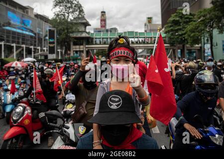 Bangkok, Thailandia. 15 agosto 2021. I tifosi della Red Shirt si riuniscono all'incrocio di Ratchaphrasong prima di un raduno motociclistico a Bangkok, Thailandia, il 15 agosto 2021. Un rally motociclistico di tutta la città, composto principalmente da Camicie rosse e guidato dall'ex legnista, Nattawut Saikuar, ha attraversato Bangkok in modo pacifico, esortando i manifestanti a non diventare violenti. Tuttavia, alcuni manifestanti, per la maggior parte gruppi giovanili come REDEM, hanno tentato ancora una volta di raggiungere la residenza del primo ministro tailandese, Prayuth Chan-OCHA, che inevitabilmente si è conclusa in scontri con le forze dell'ordine. Credit: ZUMA Press, Inc./Alamy Live News Foto Stock