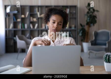 Infelice donna afroamericana stanca di lavoro informatico Foto Stock